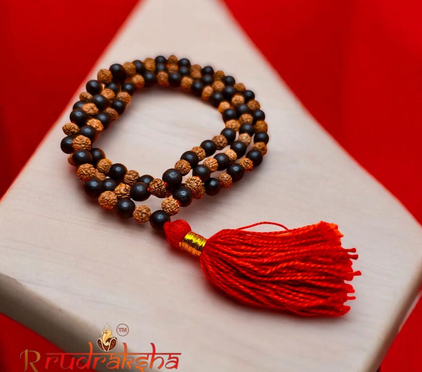 Mala necklace with Rudraksh and Karungali Malai beads and a red tassel on a white surface with a red background, featuring the R Rudraksha brand.