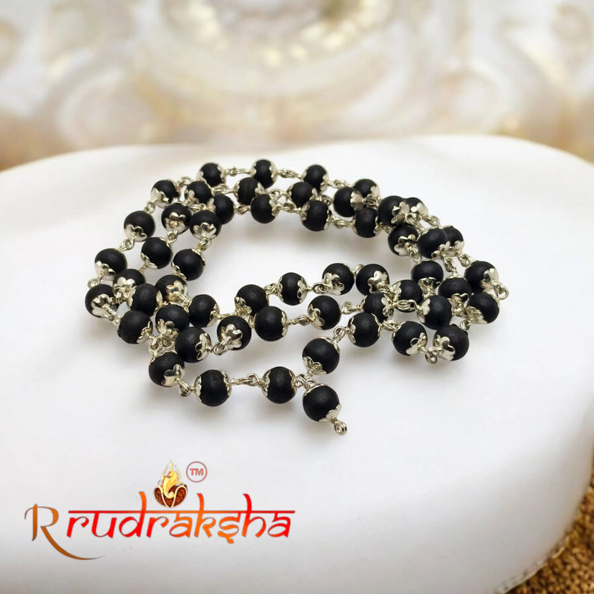 Karungali beaded necklace on a white stone with 'R Rudraksha' branding. lab Certified German Silver Mala 54 Beads