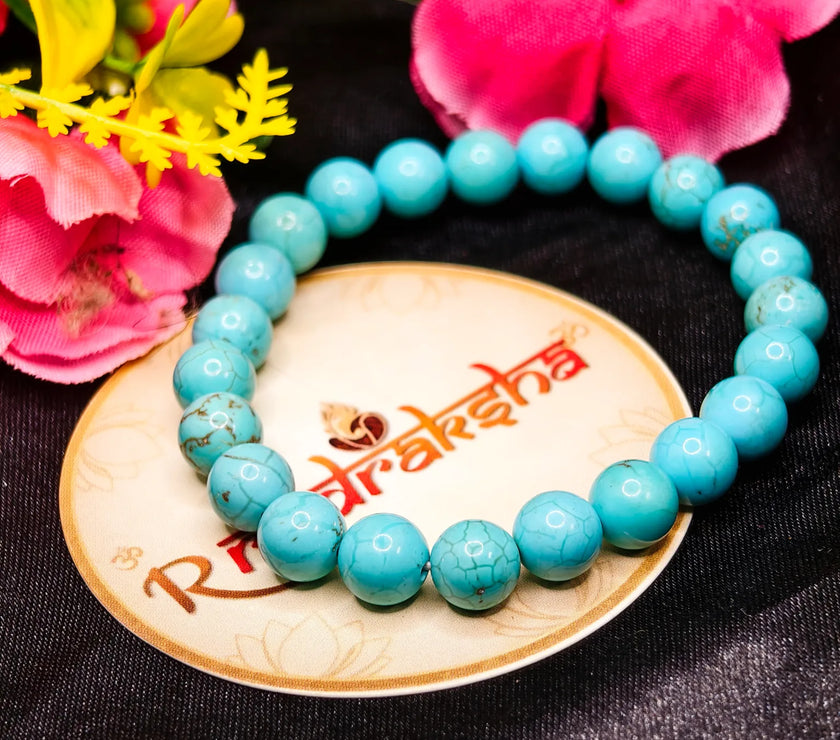 Turquoise beaded bracelet Lab Tested Authentic product on a decorative plate with flowers in the background