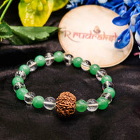 Green beaded bracelet with a brown knotted bead on a black fabric background