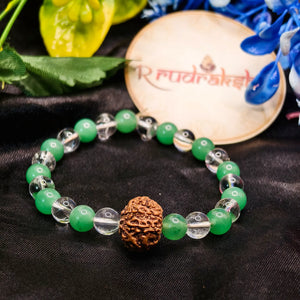Green beaded bracelet with a brown knotted bead on a black fabric background