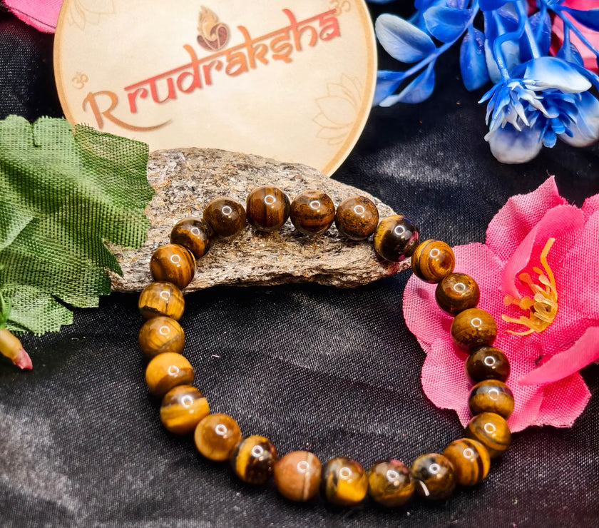 Tiger Eye Beaded bracelet Lab Certified , Premium Quality l, on a dark surface with flowers and a 'R Rudraksha' branded card